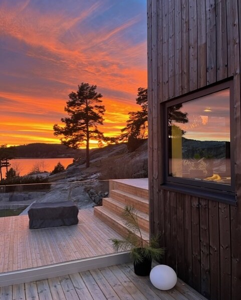 Denna moderna tappning på den klassiska fjällstugan beställdes av kund som ett fritidsboenden på en av Sveriges populära skidorter.
Huset är utvändigt klätt med svart panel och invändigt med en mörkbrun murrig panel. Den höga fönsterbeklädda gaveln vetter ut mot skidbacken och ger en vacker vidsträckt utsikt över landskapet från både allrummet och från loftets balkong. Den centrerade kaminen förstärker rummets höjd när det leder ögat upp.