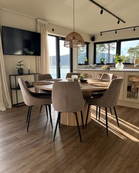 Denna moderna tappning på den klassiska fjällstugan beställdes av kund som ett fritidsboenden på en av Sveriges populära skidorter.
Huset är utvändigt klätt med svart panel och invändigt med en mörkbrun murrig panel. Den höga fönsterbeklädda gaveln vetter ut mot skidbacken och ger en vacker vidsträckt utsikt över landskapet från både allrummet och från loftets balkong. Den centrerade kaminen förstärker rummets höjd när det leder ögat upp.